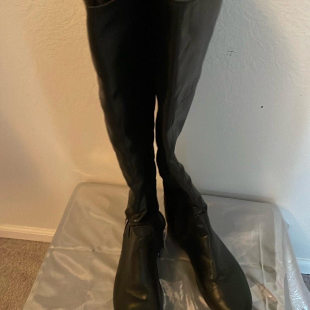 Non-heeled, black leather boots, some wear